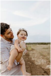 Baby girl smiles big for First Birthday Family Photos