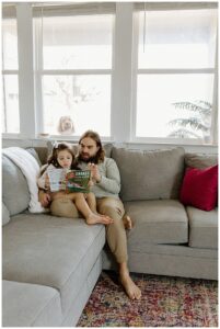 Dad and daughter sit together on the couch for Our Adventuring Souls Photography