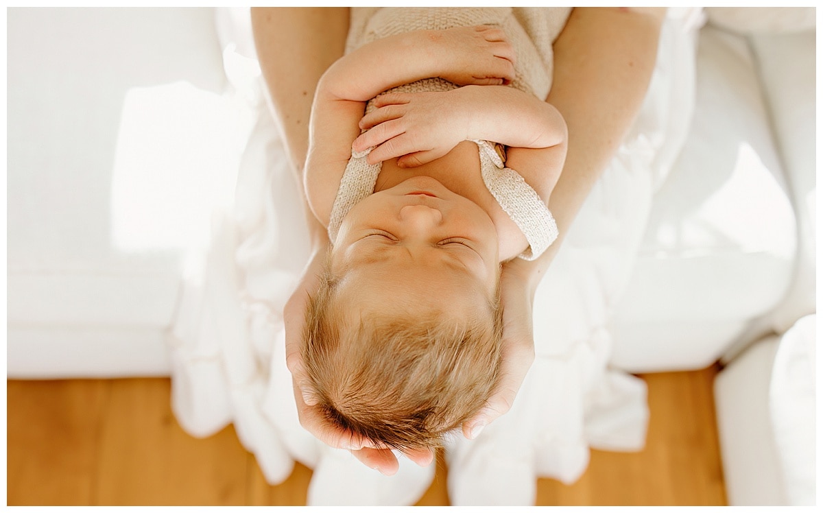 Little baby lays on parents hands for Our Adventuring Souls Photography