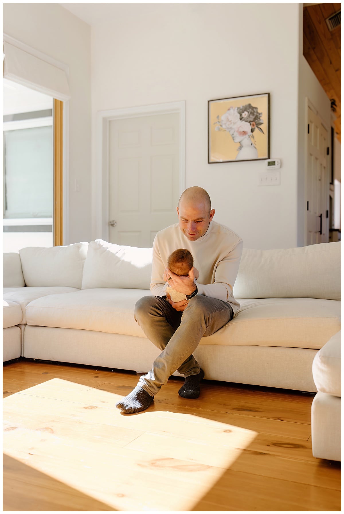 Dad stares at young baby for newborn photographer